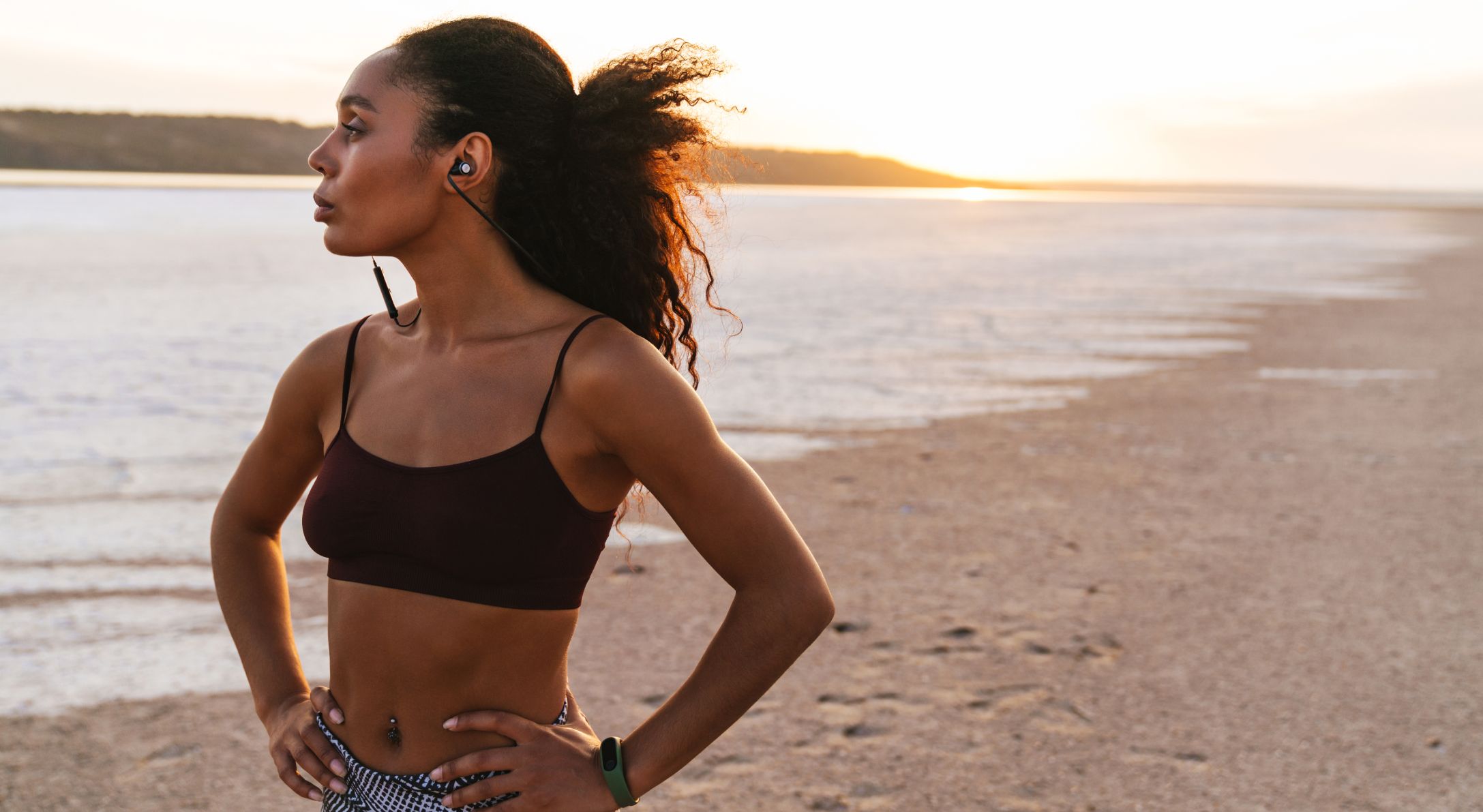 Northborough, MA Med Spa model in sportswear by the beach at sunset.