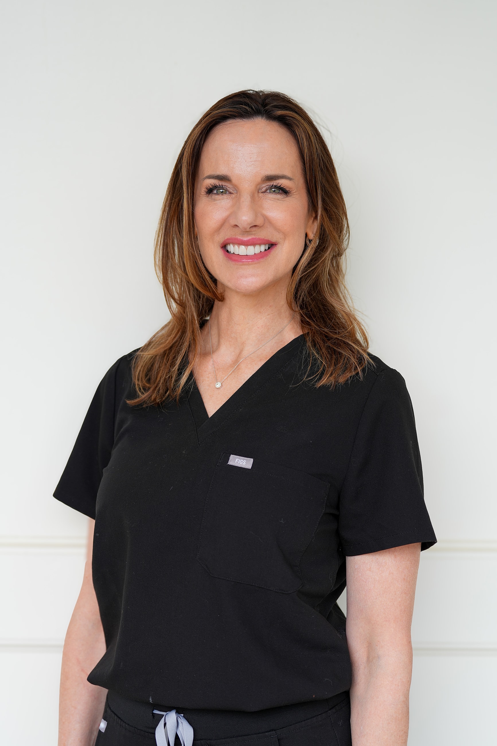 Healthcare professional smiling in black scrubs.